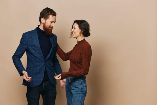 Man and woman couple in a relationship smile and interaction on a beige background in a real relationship between people