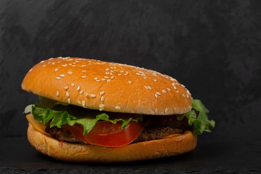 Classic hamburger close-up on a black background.