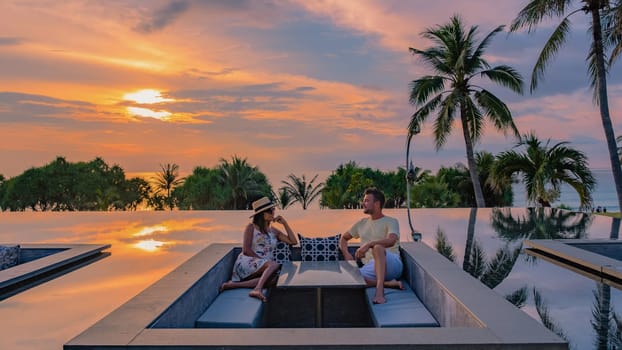 couple watching sunset in infinity pool on a luxury vacation in Thailand