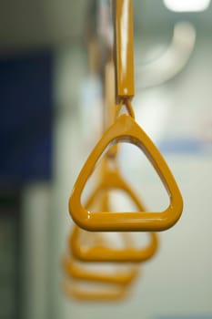 Close up and selective focus of yellow triangle handle bar in the train.