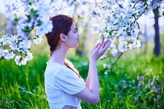 portrait of a woman standing next to a flowering tree in cold color