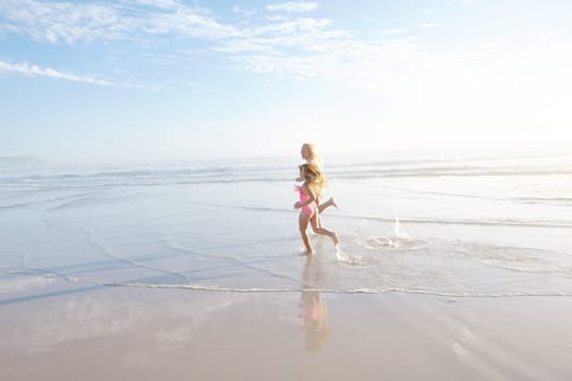 Keeping up with mom. a mother and daughter running on a beach