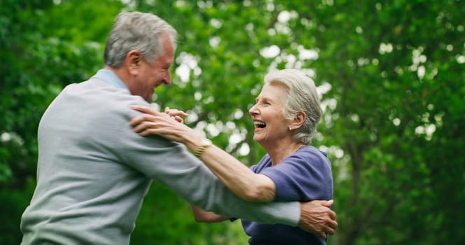 Whats life without passion. a happy senior couple dancing in the park.