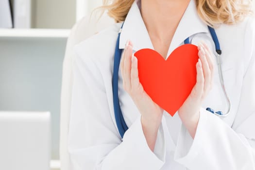Doctor holding red paper heart