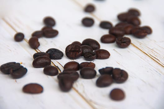Scattered coffee beans on wooden cover background with customizable space for text or coffee ideas