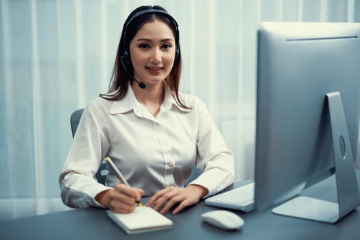 Enthusiastic asian call center with headset on her workplace portrait.