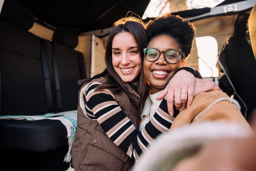 selfie of two happy women embracing in camper van