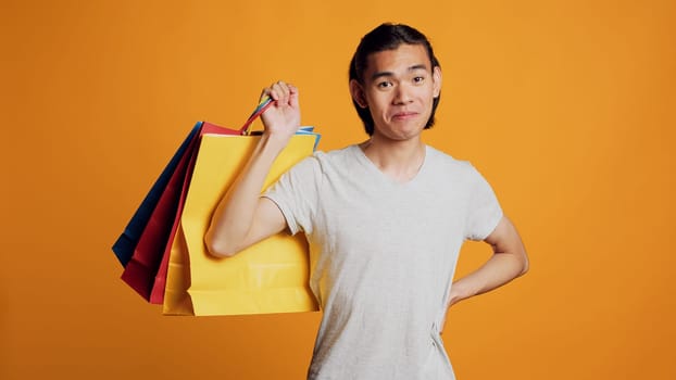 Asian cool man holding shopping bags