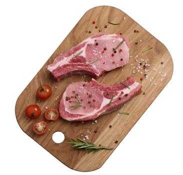 Raw pork tenderloin on the bone and spices on a wooden cutting board on a white isolated background. Portion for lunch and dinner, top view