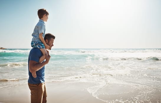 Setting off to find some adventure at the beach. a father carrying his little son on his shoulders at the beach.