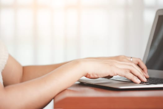 Asian woman's hand using a computer laptop