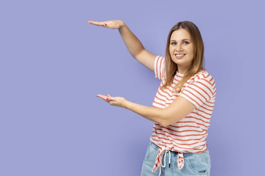 Woman presenting area between hands for advertisement, showing huge size.