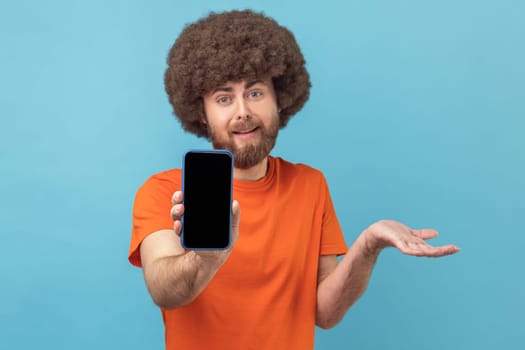 Man showing cell phone with blank black screen, presenting area for advertisement.