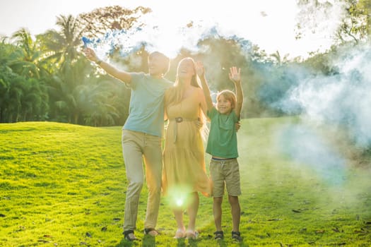 Pregnant mom, dad and son at the gender party on the golf course release blue smoke. Gender reveal announcement on the golf course. Loving family expecting baby boy. Happy moments