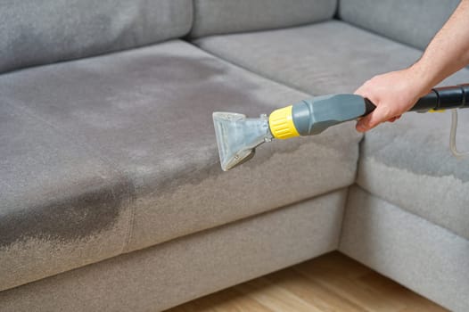 Sofa chemical cleaning with professionally extraction method. Wet textile sofa cleaning
