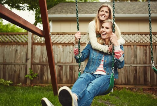 Showing her daughter unconditional love. a mother and her daughter playing on a swing in their backyard.