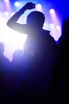 Dance, neon and silhouette of woman at music festival with crowd dancing at concert, lights and energy at live event. Party, fun and group of people, excited fans in arena at rock band performance.