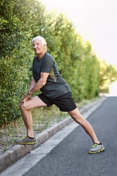 At my age its especially important to stretch properly. Portrait of a senior man warming up before a run outside.