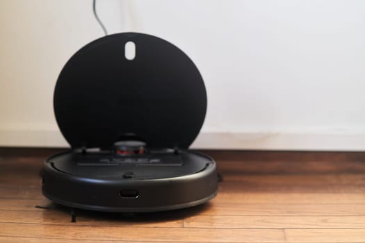 Belgrade, Serbia December 15, 2022: Black robotic vacuum cleaner is charging