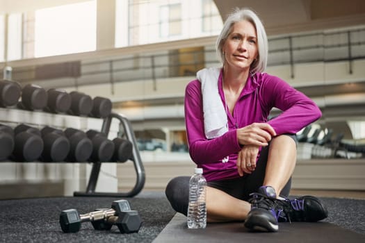 The importance of health increases with age. Portrait of a mature woman working out at the gym.
