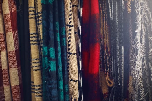 The weather might be cold, your style shouldnt be. Closeup shot of scarfs hanging in a store