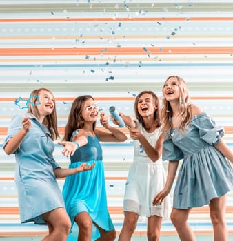 Smiling girls shoot confetti