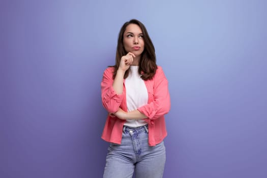 pensive dreamy european brunette 30s woman in pink shirt on studio background with copy space