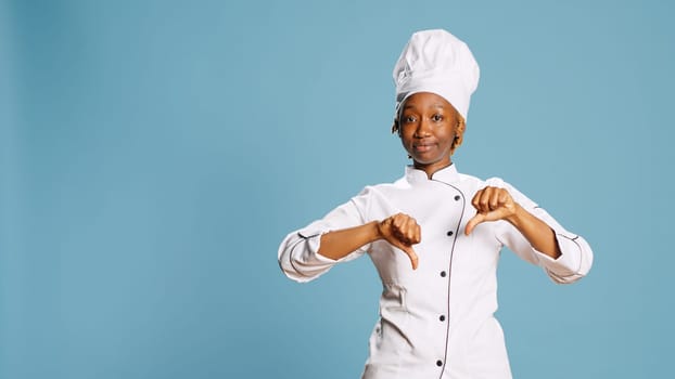 Displeased female cook showing thumbs down sign