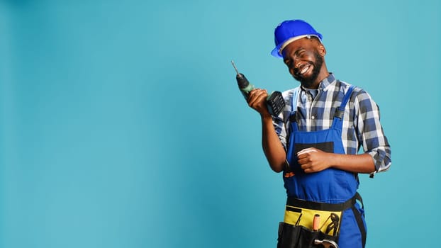 African american man using power drilling tool on wall