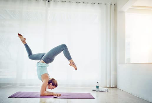 Yoga was made for me. an attractive woman practising her yoga routine at home.