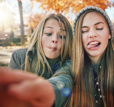 Friends are the people you can be crazy with. two young friends pulling funny faces while posing for a selfie together outside