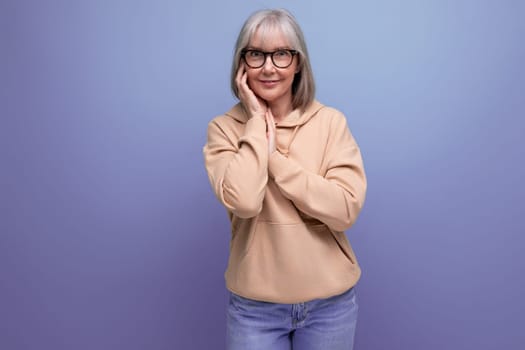 portrait of a dreamy middle-aged woman with gray hair in a casual look on a studio background with copy space