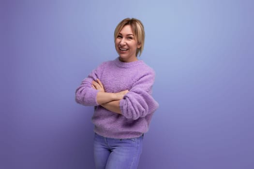 portrait of dreamy charming cute blondie woman in lavender sweater on purple background with copy space