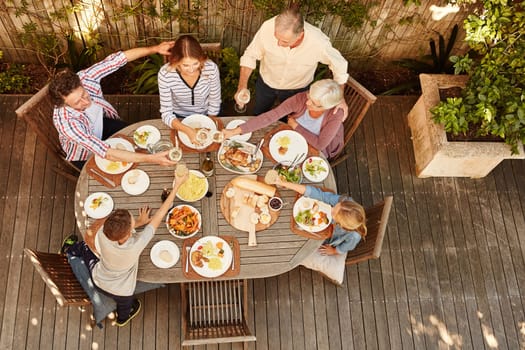 Food and family make the world a better place. High angle shot of a family eating lunch outdoors.
