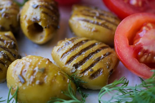 Turkish Grilled olives with olive and tomato on plate