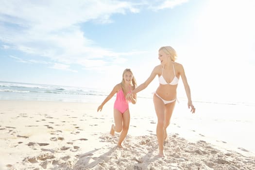 Sunshine and fun times. Portrait of a happy mother and daughter running on the beach together.