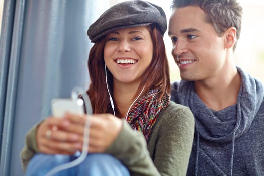 He only has eyes for her. Portrait of happy couple listening to music on their phone
