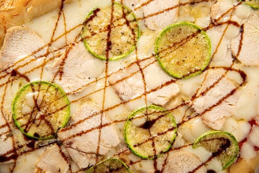 Closeup on chicken pizza with zucchini