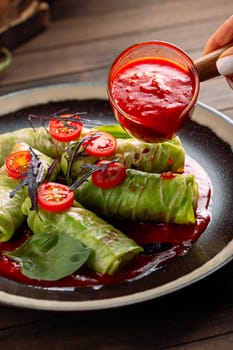 Pouring sauce on russian cabbage rolls golubtsy
