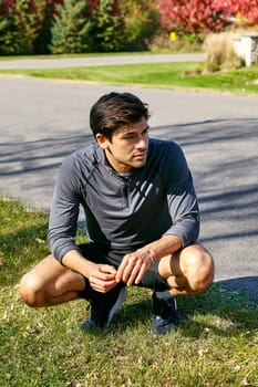 Which route should I run. a sporty young man taking a break while exercising outdoors.