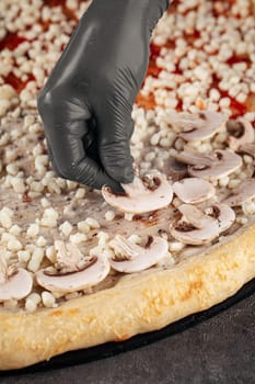 Making a pizza putting mushrooms on a dough