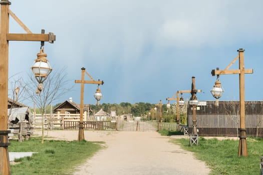Old wooden lanterns hanging on a wooden pole along the road