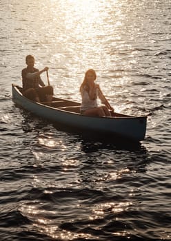 Following the course of adventure. a young couple rowing a boat out on the lake.