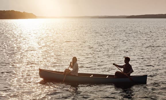 Nature is beautiful, explore it. a young couple rowing a boat out on the lake.