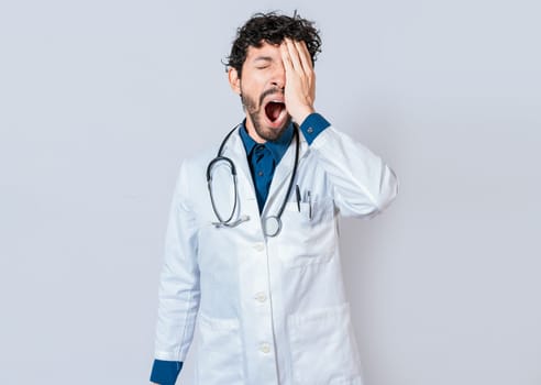 Tired and sleepy doctor isolated. Young sleepy doctor yawning on isolated background. Tired of working doctor concept