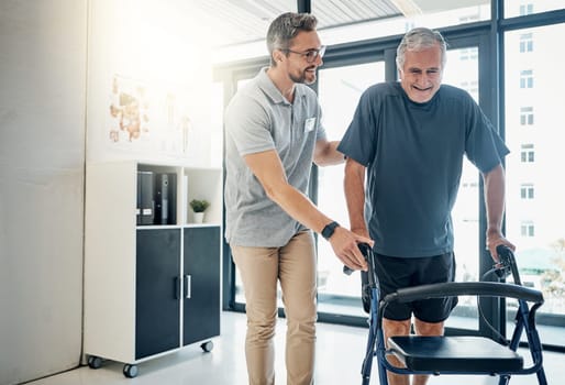 Walking the road to recovery together. a caring physiotherapist helping his mature patient to use a walker at the rehabilitation center.