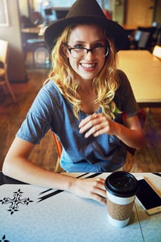 How happy she is to have her cup of coffee. a female hipster in a coffee shop.