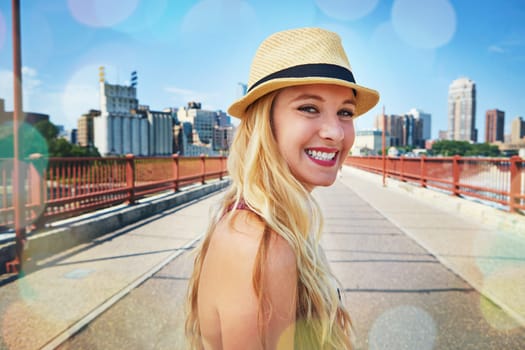 Big cities set you up for success. a smiling young woman walking around the city in the summertime.