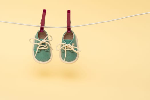 Tiny baby shoes hanging on the clothesline. Newborn concept