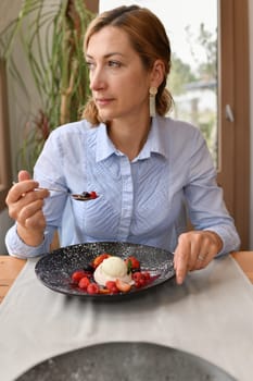 Woman eating panna cotta at a restaurant